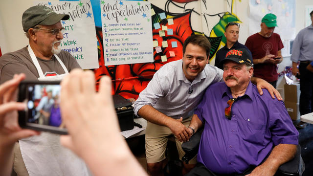 Democratic candidate Danny O'Connor poses for a photograph with Vietnam veteran Roger Tackett  ahead of Tuesday's special election, at his headquarters in Columbus, Ohio 