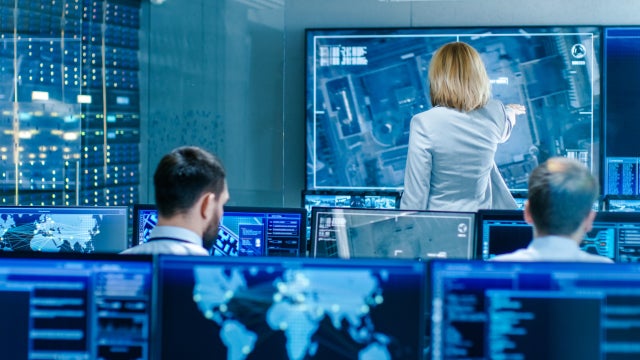 In the Government Surveillance Facility Team of Officers Organize Interception Plan with Help of Satellite Navigation. Big Screen Shows Top Down Images of the Target. 