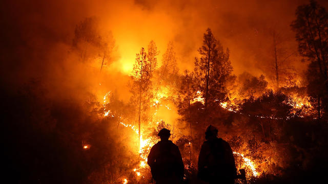 Firefighters monitor a back fire as they battle the Medocino Complex fire on Aug. 7, 2018, near Lodoga, California. 