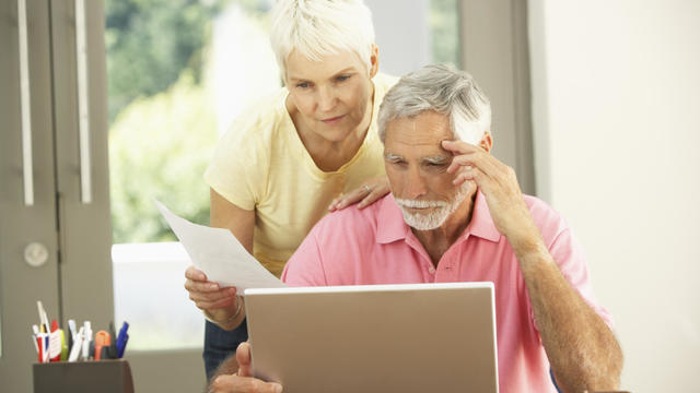Worried Senior Couple Using Laptop At Home 