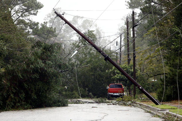 A utility pole leans precariously over a street littered with downed trees and branches after Hurricane Florence swept through Wilmington 
