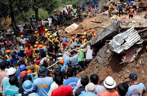 Rescuers search for people trapped in a landslide caused by Typhoon Mangkhut at a small-scale mining camp in Itogon 