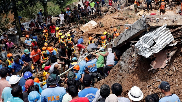 Rescuers search for people trapped in a landslide caused by Typhoon Mangkhut at a small-scale mining camp in Itogon 