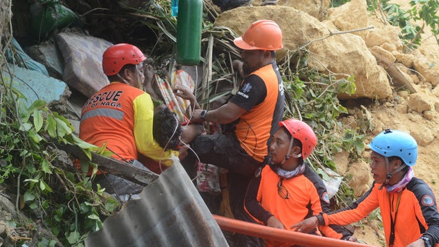 Rescuers pull out a survivor from rubble after a landslide in the City of Naga, Cebu 