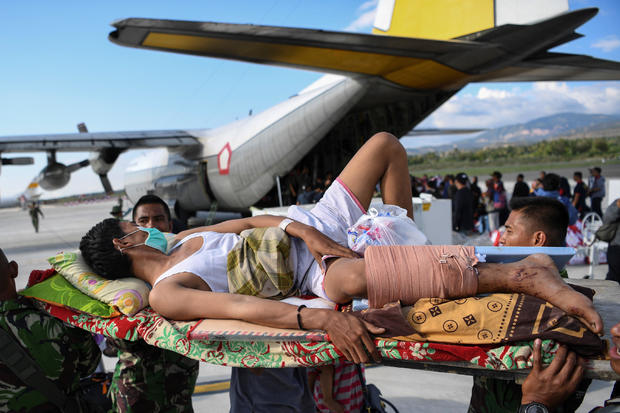 An injured man is evacuated on a military aircraft following an earthquake and tsunami at Mutiara Sis Al Jufri Airport in Palu, Central Sulawesi 