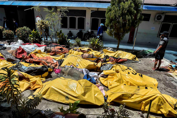 A man examines earthquake and tsunami victims who were placed outside the Bhayangkara Hospital after a quake in Palu 