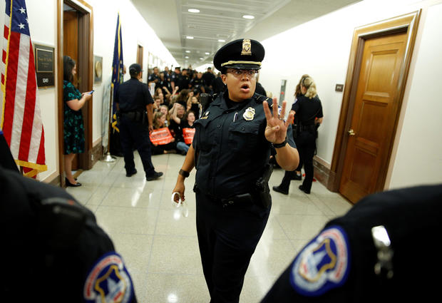 A police officer clears the hallway before demonstrators are arrested as they protest against U.S. Supreme Court nominee Brett Kavanaugh in front of the office of Senator Susan Collins (R-ME) on Capitol Hill in Washington 