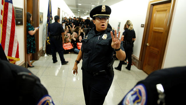 A police officer clears the hallway before demonstrators are arrested as they protest against U.S. Supreme Court nominee Brett Kavanaugh in front of the office of Senator Susan Collins (R-ME) on Capitol Hill in Washington 