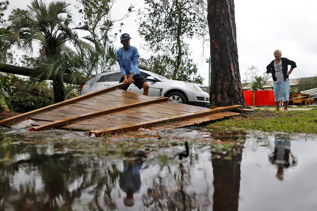 Joseph Howat clears a damaged fence by Hurricane Michael at his business in Panama City Beach 