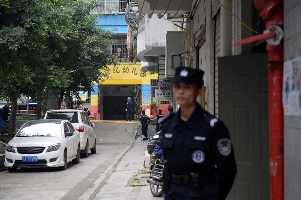 Police officers are seen outside the gate of a kindergarten where a woman armed with a kitchen knife attacked children, in Chongqing 