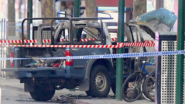 A burnt out vehicle is surrounded by police tape on Bourke Street in central Melbourne 