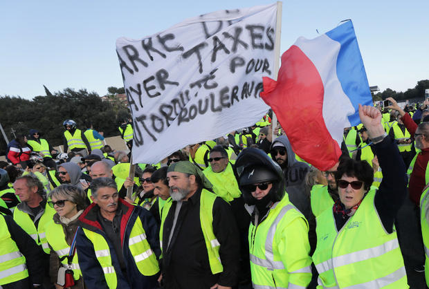 People wearing yellow vests, a symbol of a French drivers' protest against higher fuel prices, block the motorway in Antibes 