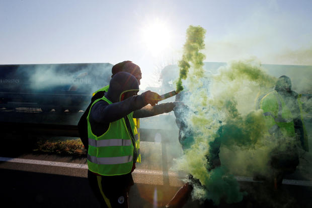 People wearing yellow vests, a symbol of French drivers' nationwide protest against higher fuel prices, block the Paris-Brussels motorway in Haulchin 