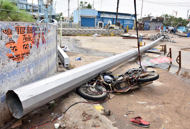 A fallen pole and a damaged motorbike are seen in a road after cyclone Gaja hit Velankanni 