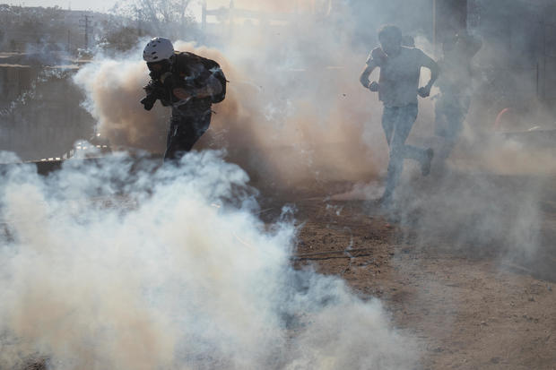 A photojournalist is surrounded in a cloud of tear gas released by U.S. Customs and Border Protection (CBP) after migrants, part of a caravan of thousands from Central America, attempted to illegally cross the border into the United States from Tijuana 