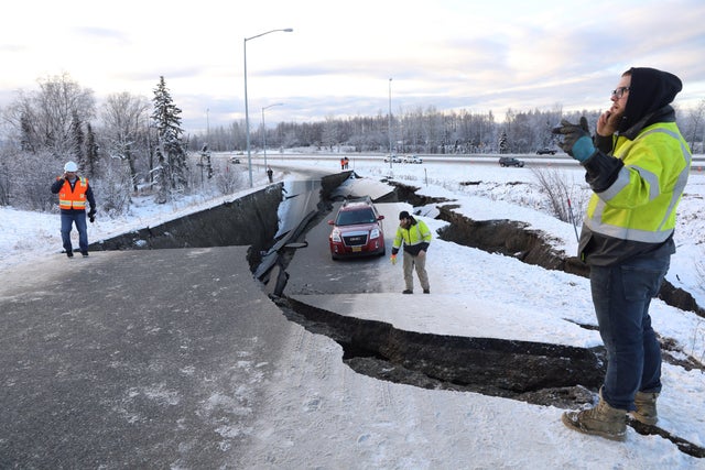 A stranded vehicle lies on a collapsed roadway near the airport after an earthquake in Anchorage