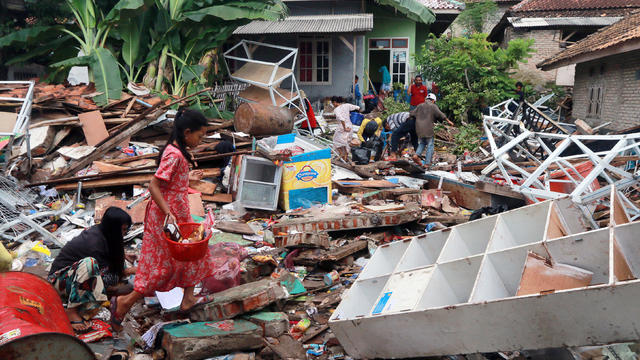 Children, who affected by the tsunami at Sunda Strait, collect snacks from a collapsed shop at Rajabasa in South Lampung 