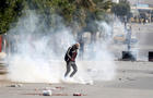 Tear gas is seen as protesters clash with riot police attempting to disperse the crowd during demonstrations, in Kasserine 