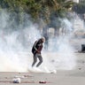 Tear gas is seen as protesters clash with riot police attempting to disperse the crowd during demonstrations, in Kasserine 