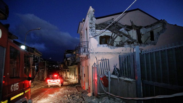 Fire fighters are seen next to a house damaged by an earthquake, measuring magnitude 4.8, at the area north of Catania on the slopes of Mount Etna in Sicily 