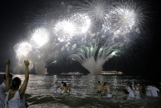 People watch as fireworks explode over Copacabana beach during New Year's celebrations in Rio de Janeiro, Brazil, Jan. 1, 2019. 