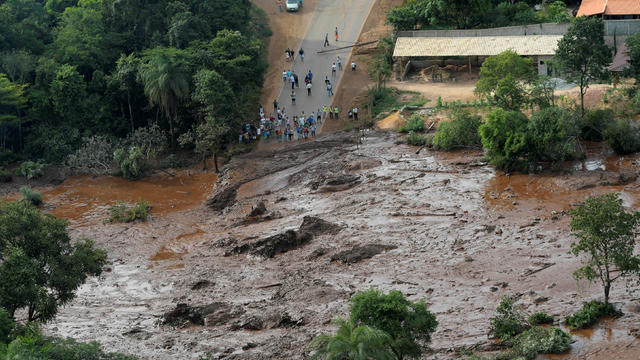 Residents are seen in an area next to a dam owned by Brazilian miner Vale SA that burst 