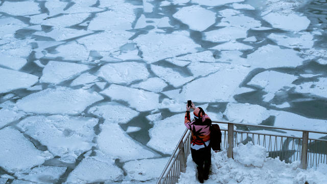 A pedestrian stops to take a photo by Chicago River as bitter cold phenomenon called the polar vortex has descended on much of the central and eastern United States 