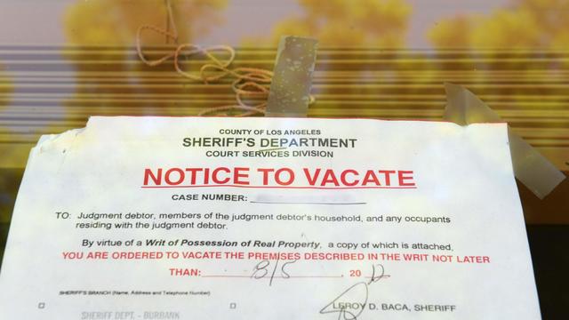 A "Notice to Vacate" is seen in the wind 