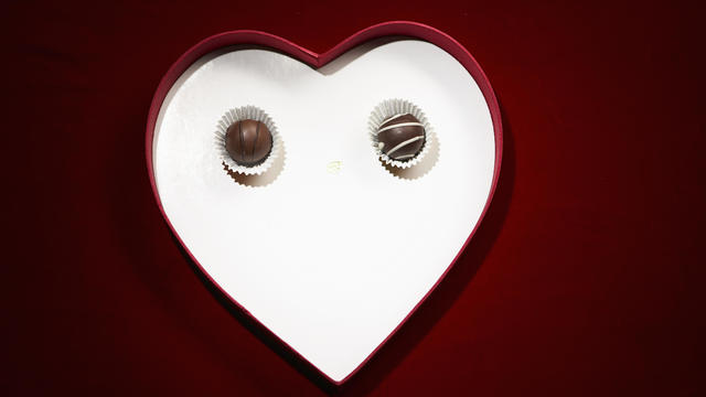 Two chocolate bon-bons in heart shaped box 