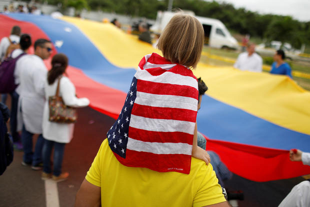 A child wearing a U.S. flag attends a gathering of Venezuelan doctors at the entrance of a warehouse where humanitarian aid for Venezuela is being stored near the Tienditas cross-border bridge between Colombia and Venezuela in Cucuta 