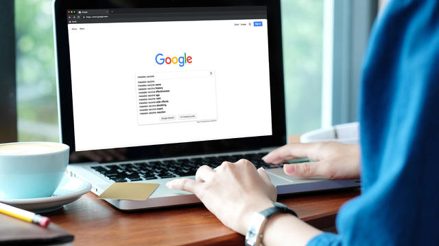 Woman searches Google on laptop computer 