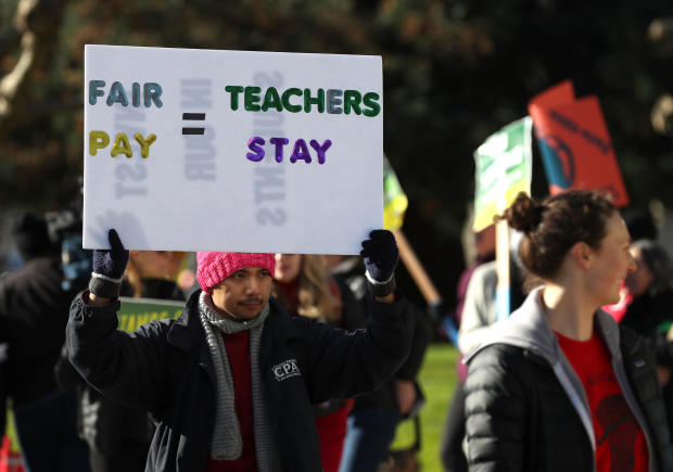 Oakland Unified School District students and teachers carry signs as they picket outside of Oakland Technical High School on Feb. 21, 2019, in Oakland, California. 