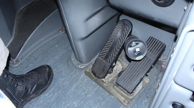 Thermos Wedged Behind Gas Pedals 