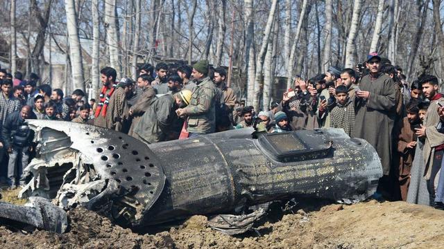 Indian soldiers and Kashmiri onlookers stand near the remains of an Indian Air Force helicopter after it crashed in Budgam district, on the outskirts of Srinagar on February 27, 2019. 