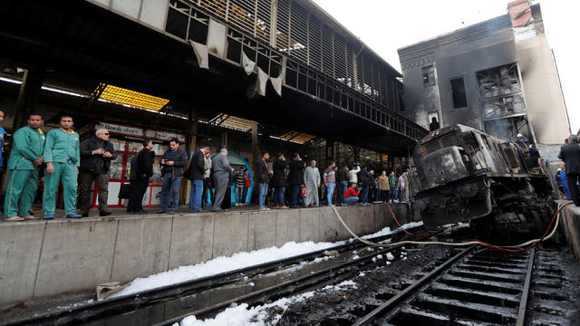 People gather at the main train station after a fire caused deaths and injuries, in Cairo 