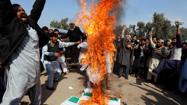 People chant slogans as they burn an effigy depicting Indian Prime Minister Narendra Modi, after Pakistan shot down two Indian military aircrafts, according to Pakistani officials, in Peshawar 