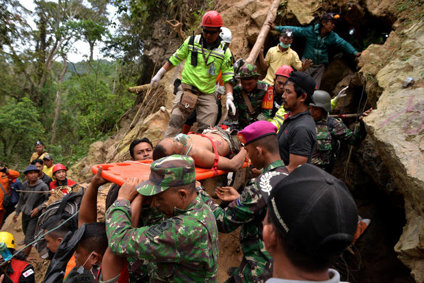 Rescue workers carry a miner who survived from the collapse of an illegal gold mine at Bolaang Mongondow regency in North Sulawesi 
