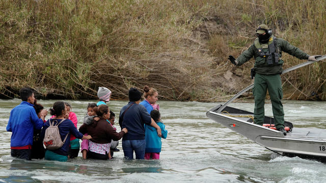 A U.S. border patrol agent gestures before rescuing migrants crossing the Rio Bravo towards the United States, in Piedras Negras 