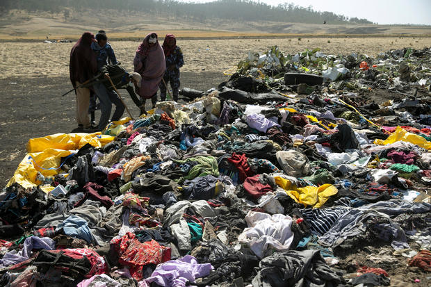 Ethiopian policemen search through the passengers belongings at the scene of the Ethiopian Airlines Flight ET 302 plane crash, near the town Bishoftu, near Addis Ababa 