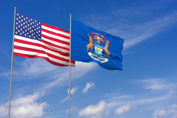 USA and Michigan flags over blue sky background. 3D illustration 