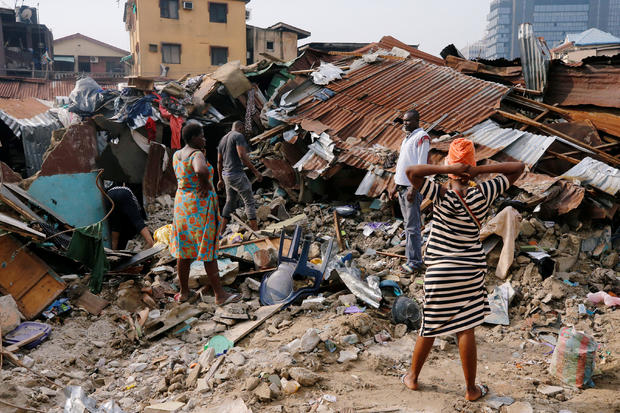 A woman searches for belongings at the site of a collapsed building in Nigeria's commercial capital of Lagos 