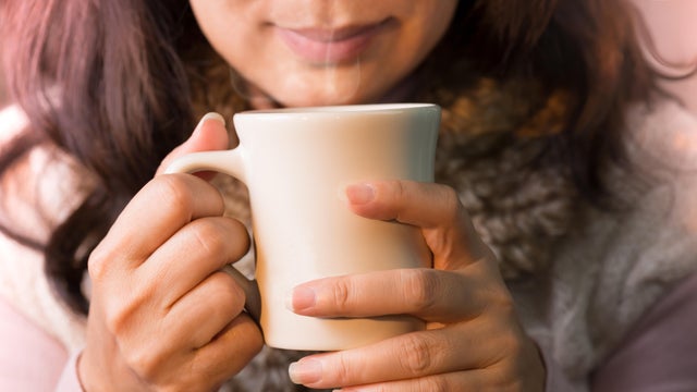 Close up of woman hands holding a cup of coffee. 