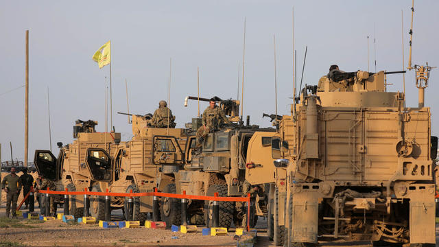 American soldiers stand near military trucks, at al-Omar oil field in Deir Al Zor 