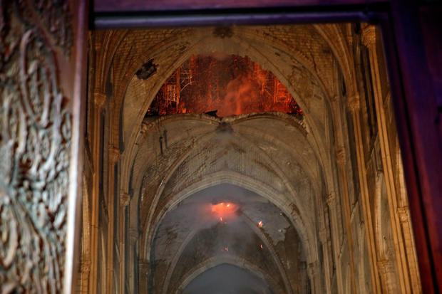 Flames are seen as the interior continues to burn inside the Notre Dame Cathedral in Paris 
