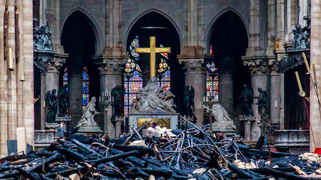The cross and sculpture of Pieta by Nicolas Coustou are seen surrounded by debris inside Notre Dame Cathedral in the aftermath of a fire that devastated the church during a visit by French Interior Minister Christophe Castaner, not pictured, in Paris, Fra 
