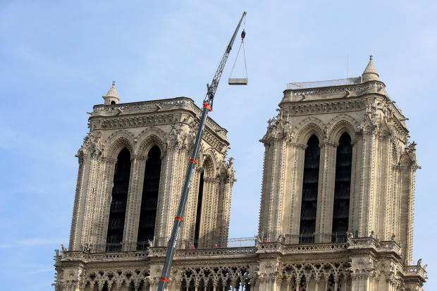A crane works between the two towers at Notre Dame Cathedral days after a massive fire devastated large parts of the Gothic structure in Paris, France, April 18, 2019. 