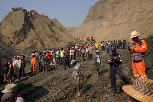 Local people look on in a jade mine where the mud dam collapsed in Hpakant 