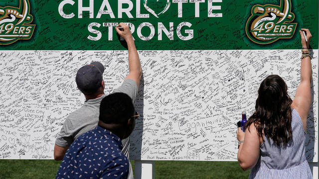 FILE PHOTO: Patrons sign a board to show their sentiments in support of UNC Charlotte after the recent shooting deaths during the second round of the Wells Fargo Championship golf tournament at the Quail Hollow Club in Charlotte 