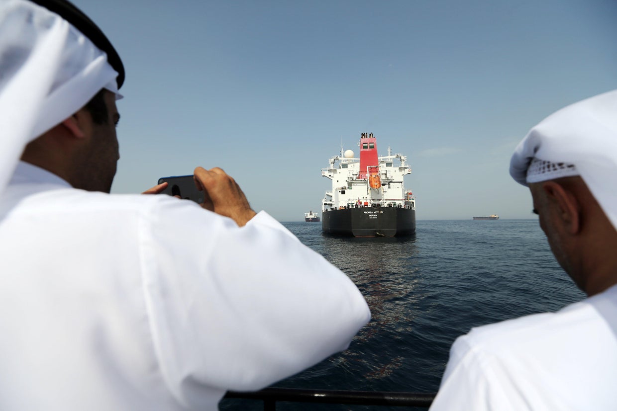 Port officials take a photo of a damaged Andrea Victory ship at the Port of Fujairah 