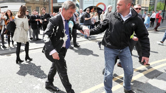 Brexit Party leader Nigel Farage gestures after being hit with a milkshake while arriving for a Brexit Party campaign event in Newcastle, Britain, May 20, 2019. 